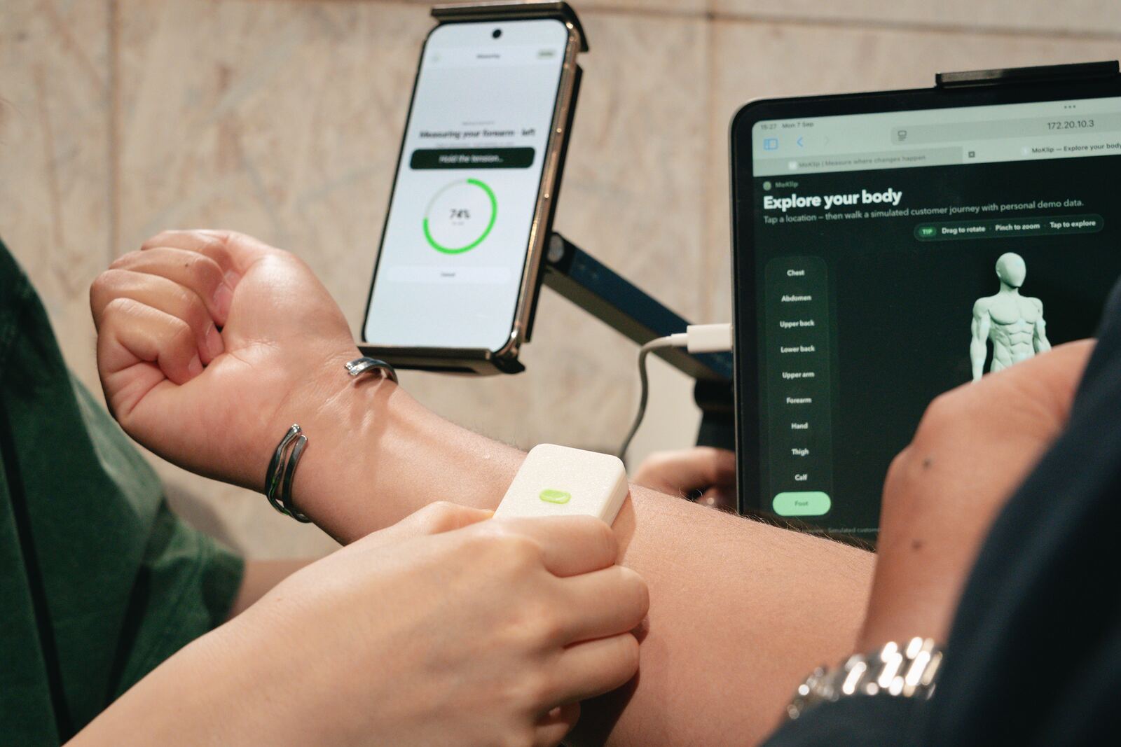 MoKlip clip on the forearm with the companion app on phone and tablet