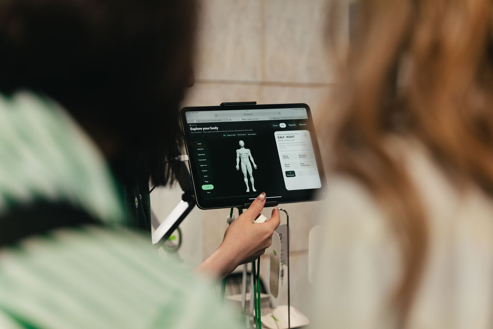 Visitor exploring the body map on a tablet at the MoKlip stand